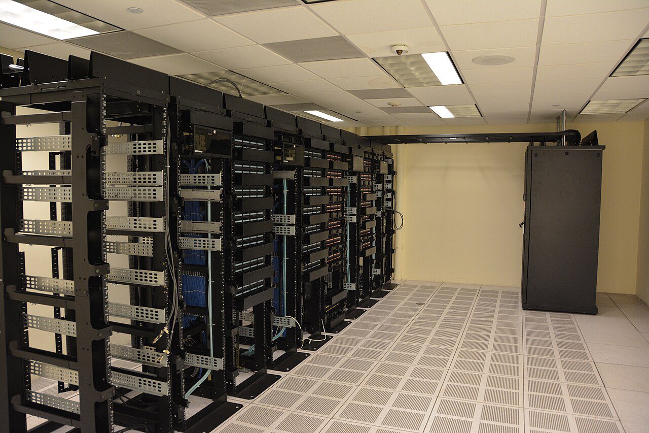 Rows of server racks inside a data center, the kind of facility that powers AI models