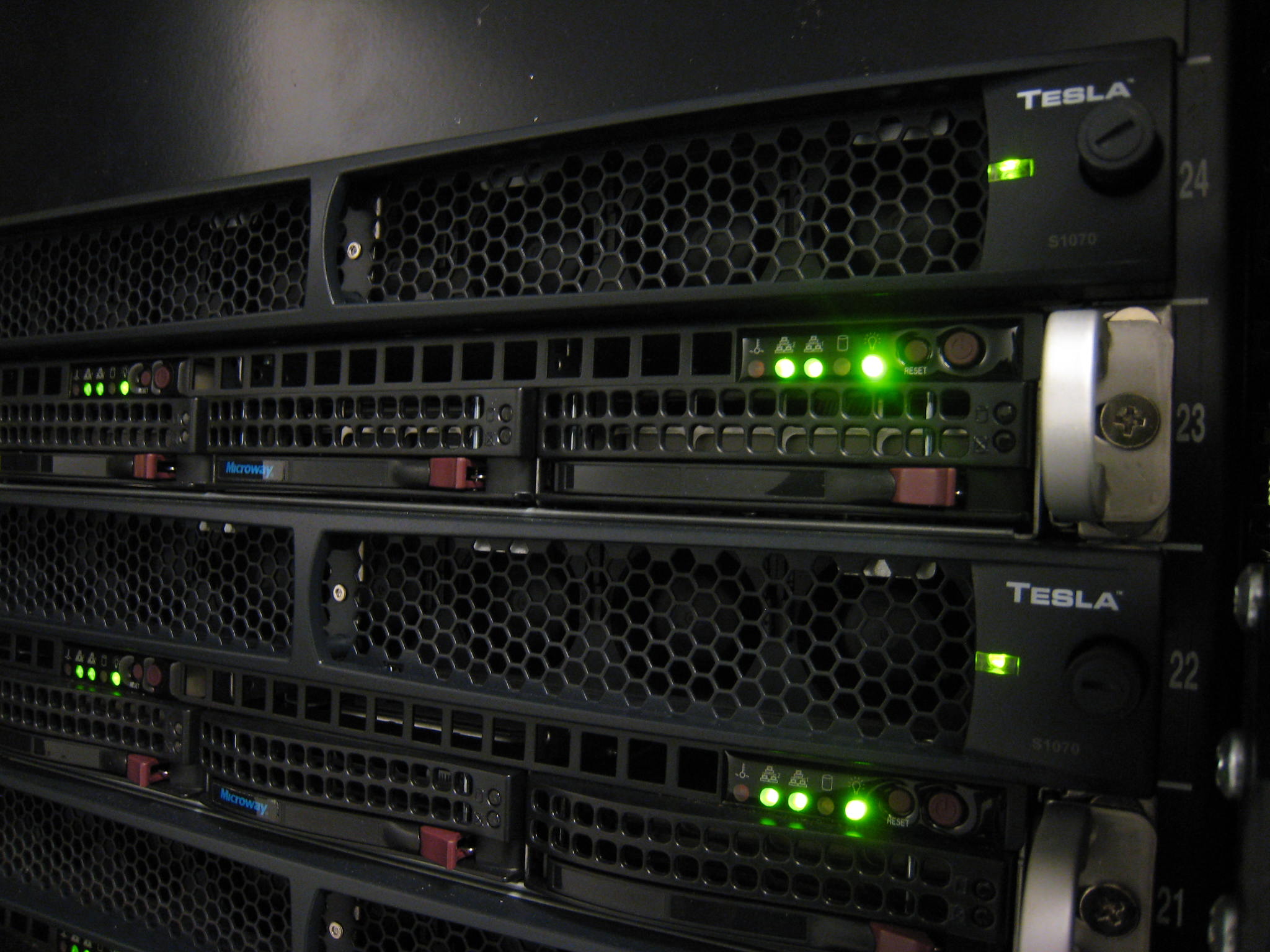 A cluster of NVIDIA GPU servers connected by networking cables, the kind of hardware that makes up an AI factory